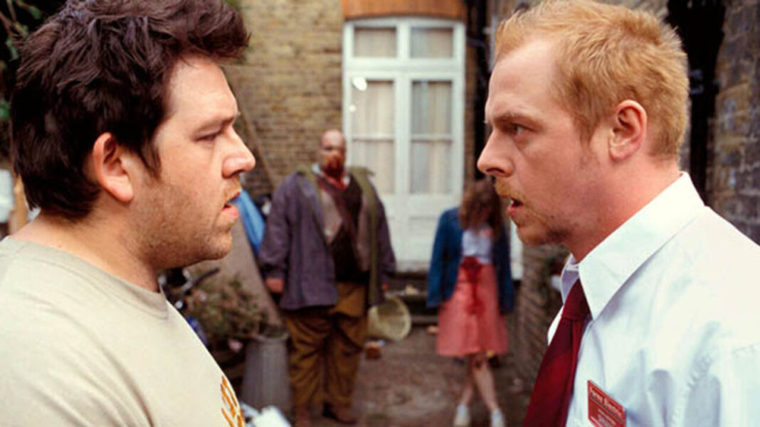 Shaun and Ed staring at each other in front of zombies in Shaun of the Dead
